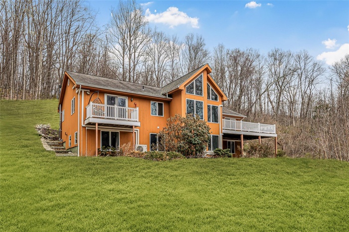Rear view of house with a yard and a deck