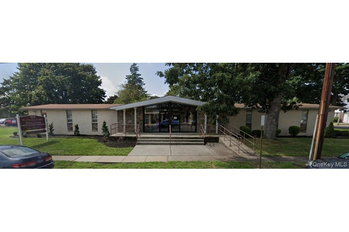 View of front facade featuring a front lawn, brick siding, and a porch