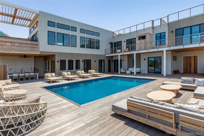 Swimming pool featuring an outdoor hangout area, a wooden deck, and a patio area