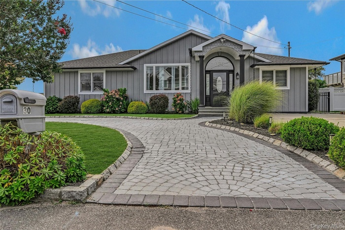 Single story home featuring a shingled roof, board and batten siding, and a front yard