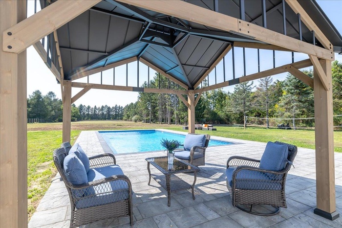 Pool with a gazebo, a lawn, and a patio