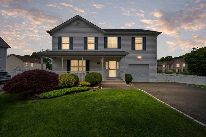 View of front of home featuring an attached garage, a porch, and driveway