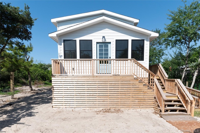 View of front of home featuring stairway and a wooden deck