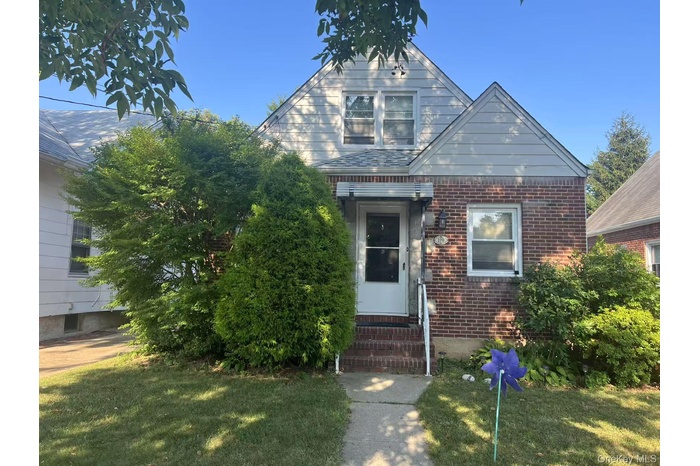 View of front of property with brick siding and a front yard