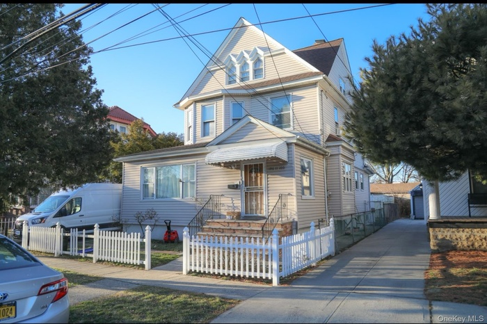 Victorian-style house featuring an outbuilding and a fenced front yard