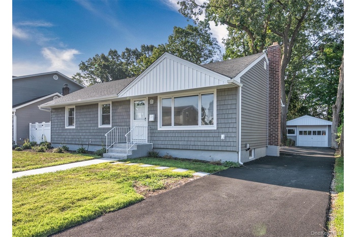 Front of home featuring new vinyl siding and a 1.5 car detached garage