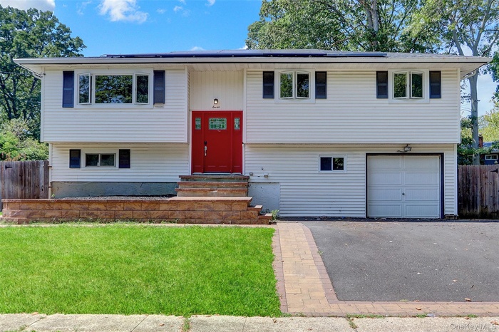 Split foyer home with a garage, asphalt driveway, and entry steps