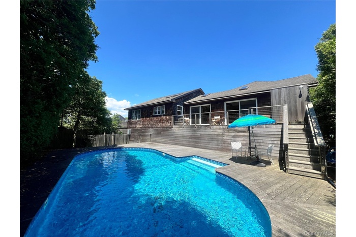 View of pool with a patio, stairs, and a deck