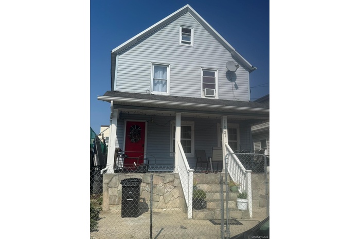 View of front of home with a gate, a fenced front yard, a porch, and roof with shingles