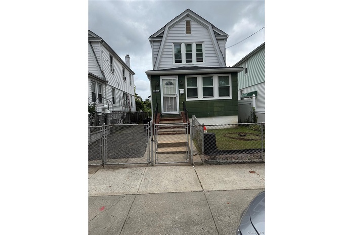 Dutch colonial with a gate, a gambrel roof, and a fenced front yard
