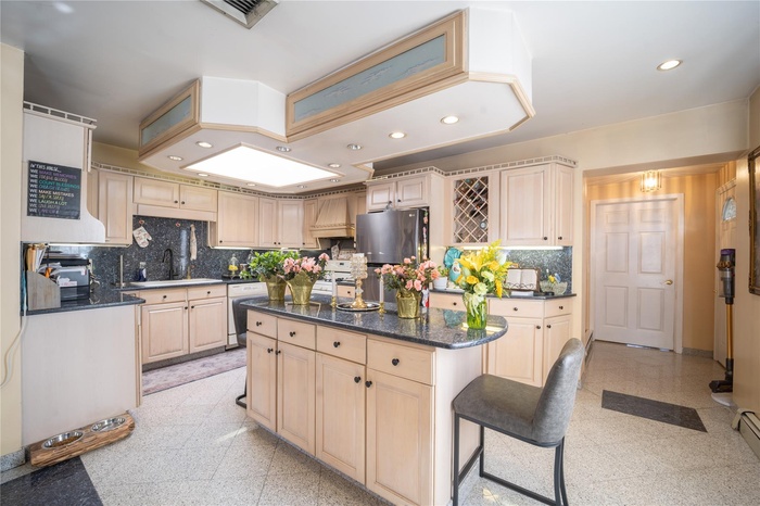 Open kitchen with Island table, refrigerator, dishwashing machine, and recessed lighting