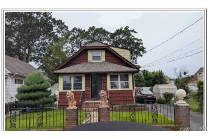 Bungalow-style house featuring a fenced front yard, driveway, and a gate