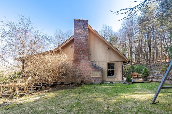 Back of property featuring a lawn and a chimney