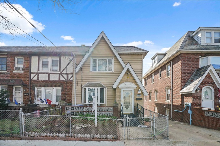 View of front of home featuring brick siding, cooling unit, a gate, and a fenced front yard
