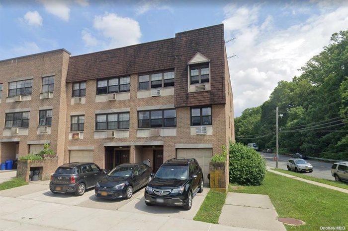 View of building exterior with driveway and a garage