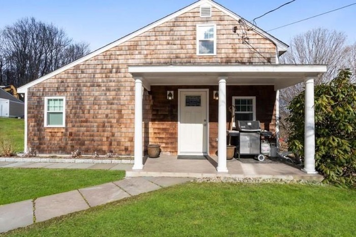 View of front of home featuring a porch and a front lawn