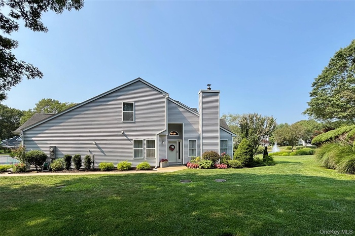 View of front facade with a chimney and a front lawn