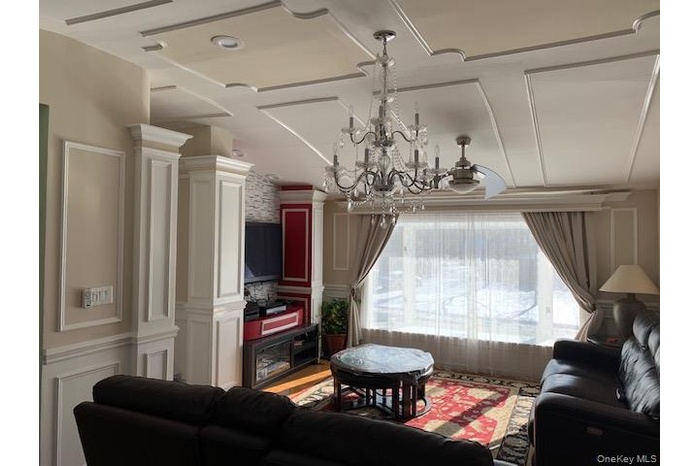 Living room with a chandelier and a decorative wall