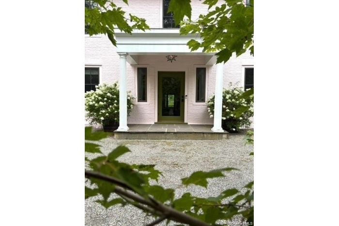 Doorway to property with a porch and brick siding