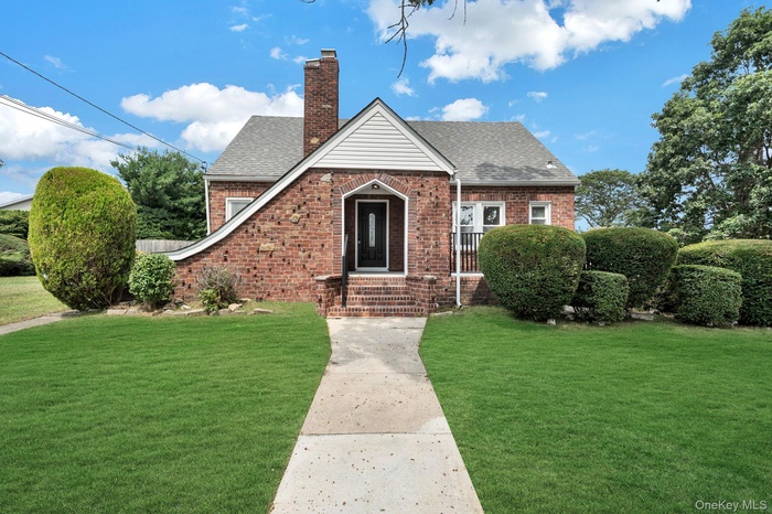 Tudor-style house with a shingled roof and a front lawn
