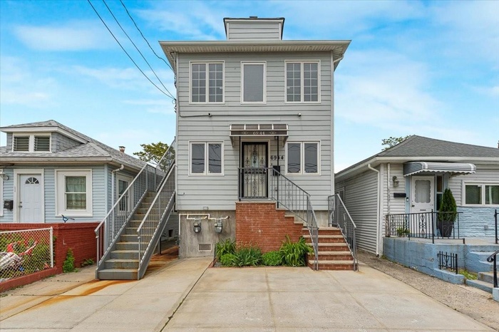 American foursquare style home featuring a chimney and stairs