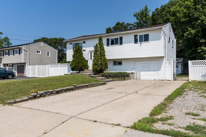 Split foyer home featuring an attached garage and concrete driveway