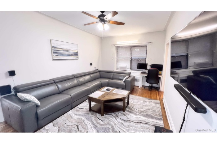 Living area with light wood-style floors, an office area, and ceiling fan