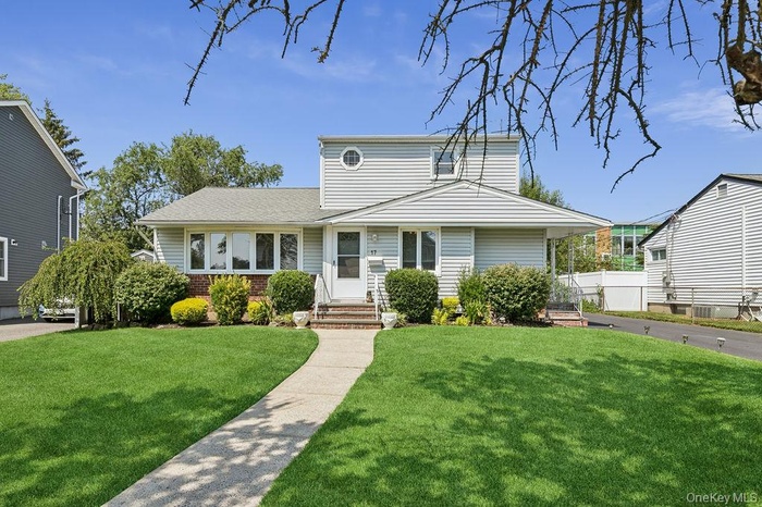 View of front of property featuring brick siding, entry steps, and a shingled roof