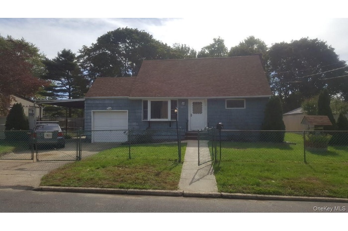 View of front of home featuring concrete driveway, a garage, a gate, a fenced front yard, and a carport