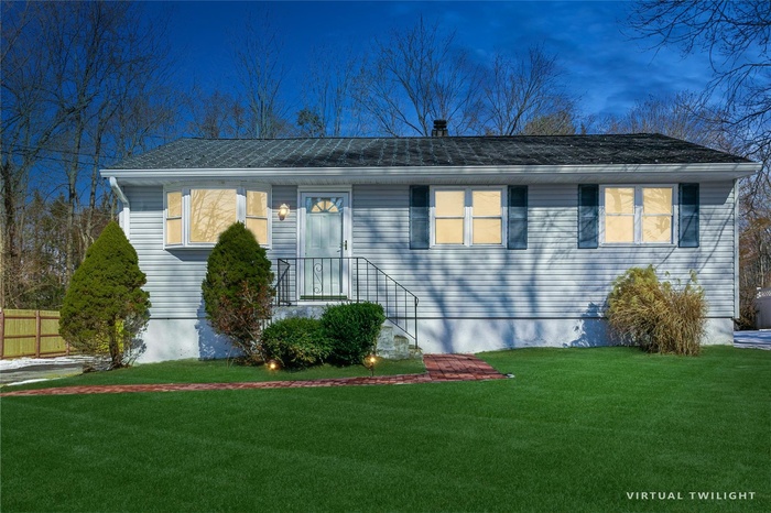 View of front of property with a front yard and fence
