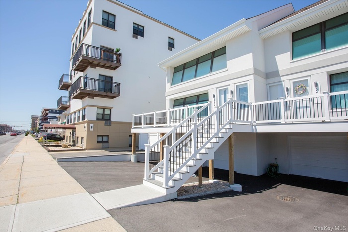 View of property with stairway and an attached garage