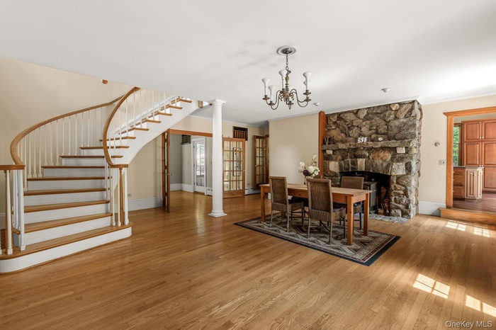 Great room w dining area, wood floors, staircase and a fireplace with wb incert