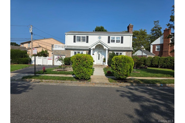 View of front of property with driveway and a chimney