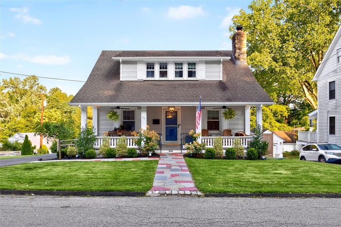 Delightful home featuring an expansive porch and beautiful perennial plantings.