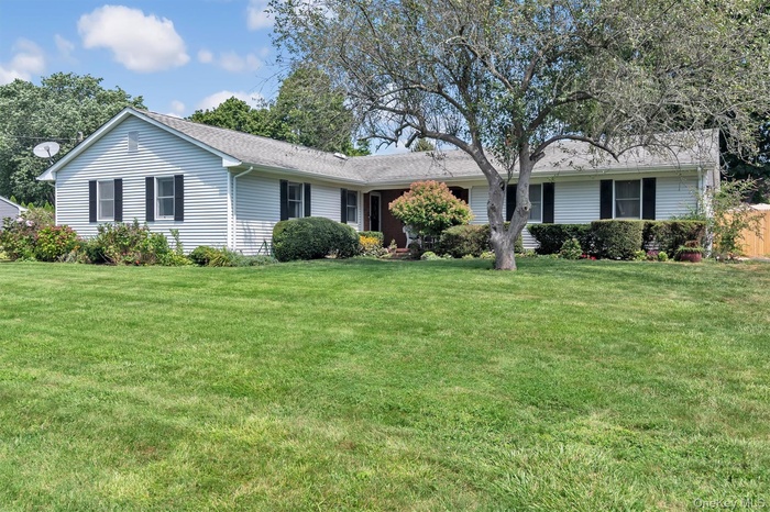 Ranch-style house featuring a front lawn and a shingled roof