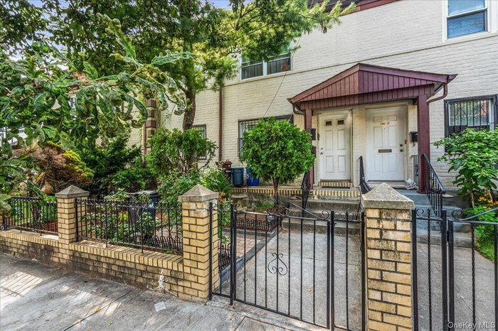 View of front of property with a gate, a fenced front yard, and brick siding