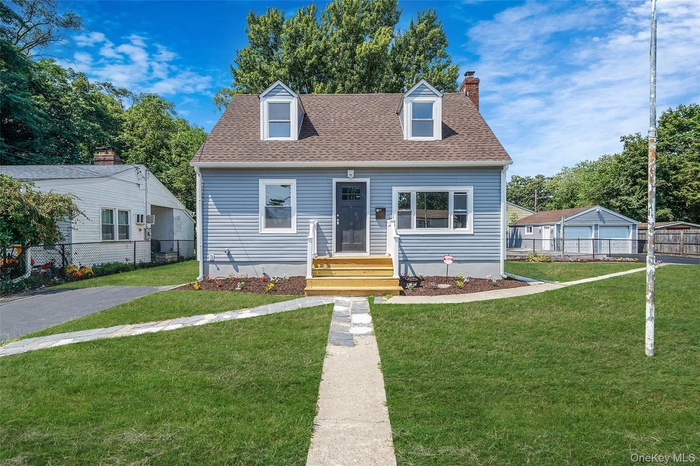 Cape cod-style house featuring roof with shingles and a chimney