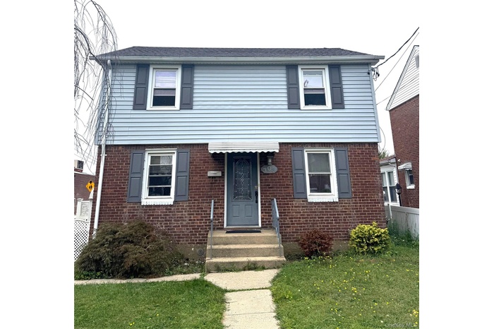 View of front of property with brick siding and a front lawn