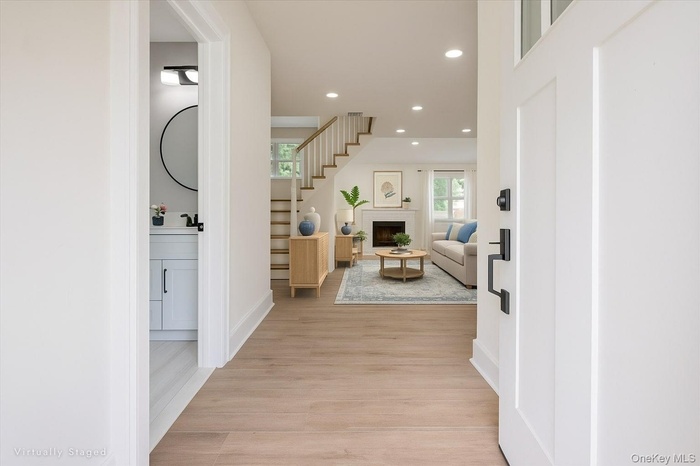 Hallway featuring recessed lighting, light wood-style floors, and stairway