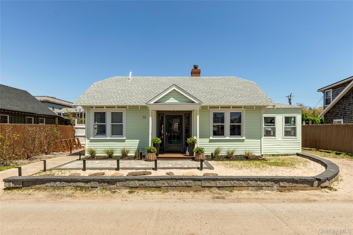 Bungalow-style house with roof with shingles and a chimney