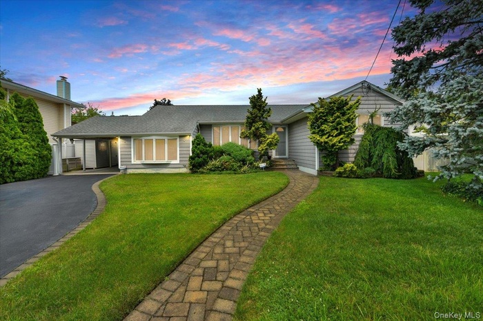 Single story home with a yard, asphalt driveway, and roof with shingles