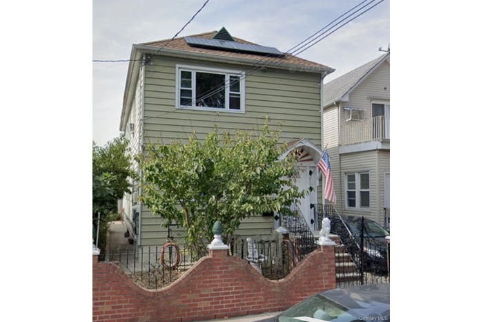 View of front facade featuring roof mounted solar panels and a balcony