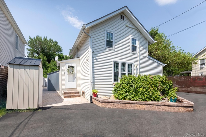View of side of property with a storage shed