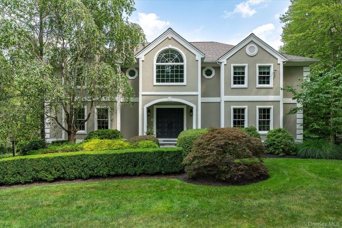 View of front of home featuring stucco siding and a front yard