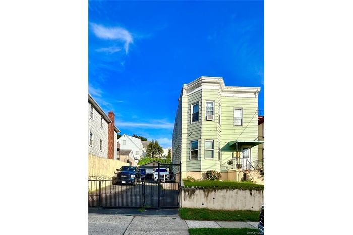 View of home's exterior featuring uncovered parking and a gate