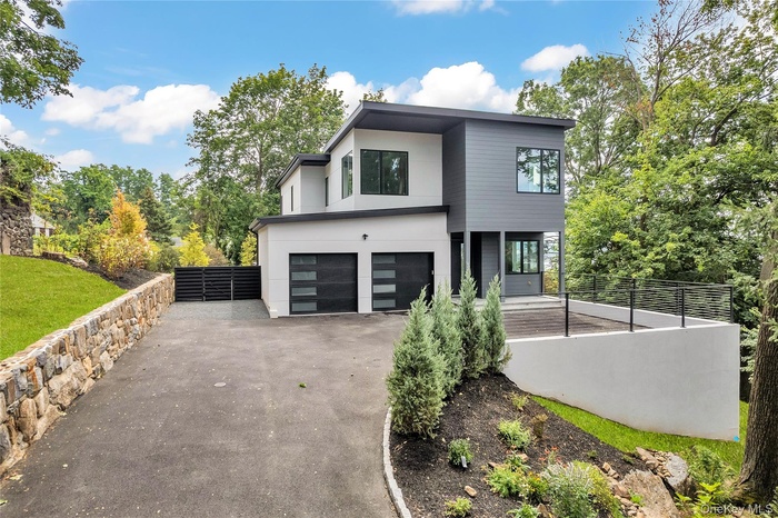 Contemporary home with driveway, stucco siding, and a garage