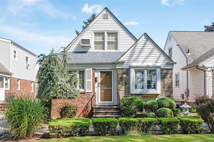 View of front of property featuring stone siding, a shingled roof, and entry steps
