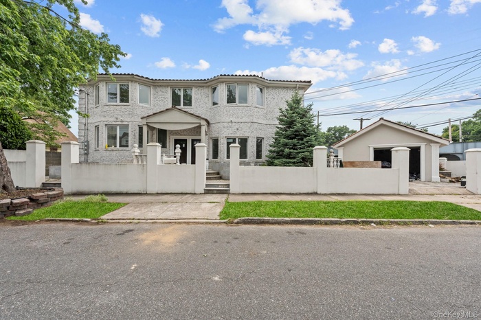 Mediterranean / spanish-style home featuring a tile roof, a fenced front yard, and a gate
