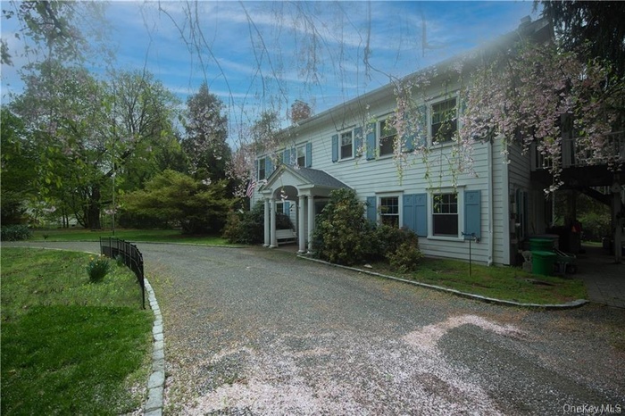 Italianate home with a chimney and circular driveway