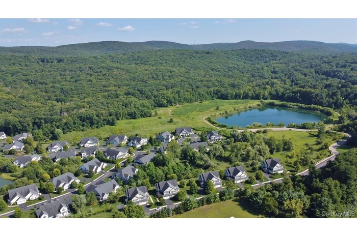 Aerial overview of property's location with a water and mountain view and nearby suburban area